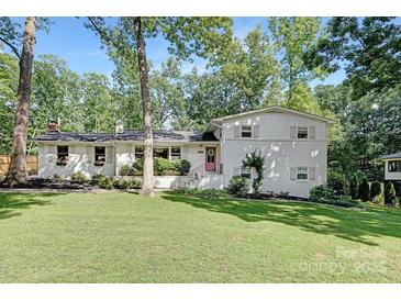 Charming white two-story home with a well-manicured lawn and beautiful landscaping at 5611 Robinhood Rd, Charlotte, NC 28211