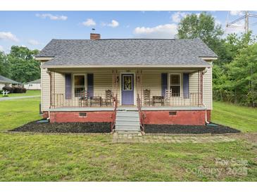 Charming single-story home with a cozy front porch, purple shutters and a landscaped yard at 626 Cabarrus W Ave, Concord, NC 28027