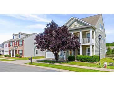 Two-story home with manicured lawn, inviting porch, and tasteful landscaping under a bright blue sky at 8312 Compton Acres Ln, Waxhaw, NC 28173
