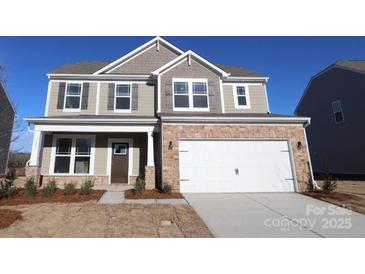 Charming two-story home featuring stone accents, neutral siding, and a spacious two-car garage at 1821 Augustine St, Monroe, NC 28112