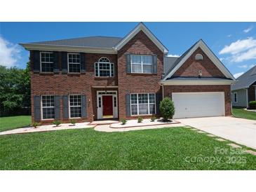 Charming brick home features a manicured lawn, red front door, and two-car garage at 219 Harrowfield Hts, York, SC 29745