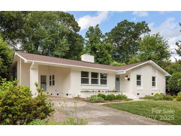 Charming brick home featuring a landscaped front yard and a light blue front door at 4017 Sulkirk Rd, Charlotte, NC 28210