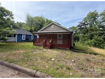 A cozy one-story home featuring a charming red porch in a wooded area at 408 Orange St, Shelby, NC 28150