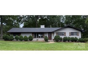 Charming brick home featuring a well-manicured lawn and lovely shrubbery at 605 Impala Dr, Albemarle, NC 28001