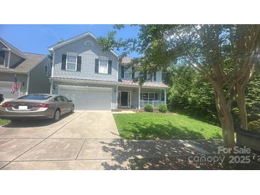 Charming two-story home featuring a well-maintained lawn, a two car garage, and a welcoming front porch at 7218 Cascading Pines Dr, Fort Mill, SC 29708