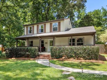 Charming two-story home with a inviting covered porch, lush landscaping, and a well-manicured lawn at 911 Munday Ct, Charlotte, NC 28270