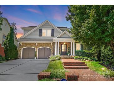 Charming two-story home with stone accents, manicured landscaping, and a brick walkway leading to the front door at 21319 Baltic Dr, Cornelius, NC 28031