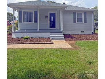 Charming single-story home with light gray siding, a cozy front porch, and a well-maintained lawn at 3412 1St Avenue Nw Cir, Hickory, NC 28601