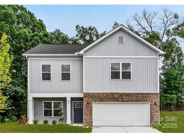 Charming two-story home with gray siding, brick accents, a two-car garage, and manicured landscaping at 8036 Joy Crossing Ln, Charlotte, NC 28214