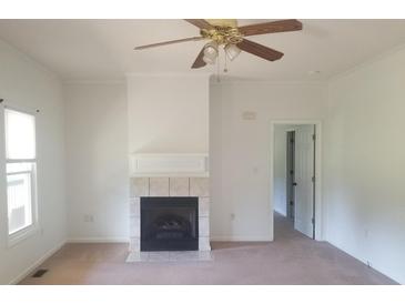 Bright living room with fireplace, ceiling fan, and neutral carpet flooring at 814 Carved Oak Ct, York, SC 29745