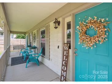 Inviting front porch with seating and a charming turquoise front door adorned with a wreath at 10206 Washam Potts Rd, Cornelius, NC 28031