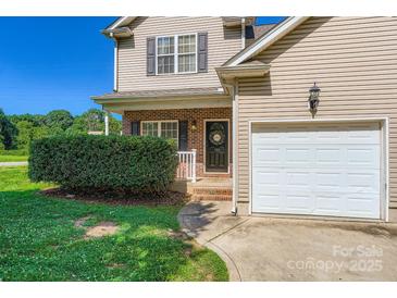Charming two-story home with a brick entryway, manicured landscaping, and a convenient attached garage at 130 Ridge Bluff Rd, Mooresville, NC 28115