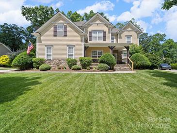 Charming two-story home with a manicured lawn, stone accents, and an inviting front porch at 1808 Mill Chase Ln, Waxhaw, NC 28173