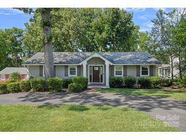 Charming home with welcoming front porch, well-maintained lawn, and mature trees at 21212 Rio Oro Dr, Cornelius, NC 28031