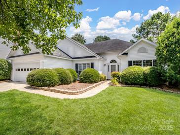Charming one-story home with manicured lawn and lush landscaping in a suburban neighborhood at 3720 Winterberry Nw Ct, Concord, NC 28027