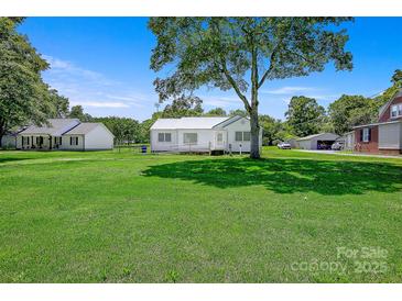 Charming single-story home with a well-maintained lawn and mature trees on a sunny day at 4555 Us 601 Hwy, Salisbury, NC 28147