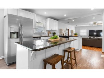 Bright kitchen with stainless steel refrigerator, black granite countertops, and white cabinets at 50 Isenhour Park Rd, Taylorsville, NC 28681