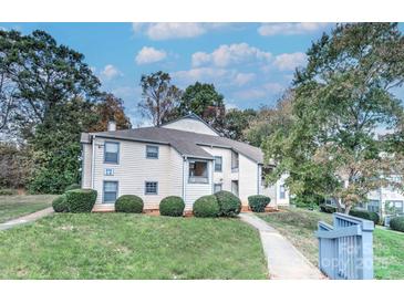 Two-story condo with manicured landscaping and a well-maintained exterior under a partly cloudy sky at 8115 Tremaine Ct, Charlotte, NC 28227