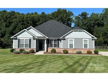 Charming single-story home with gray siding, black shutters, stone accents, and a well-manicured lawn at 231 Glenwood Dr # 4, Oakboro, NC 28129