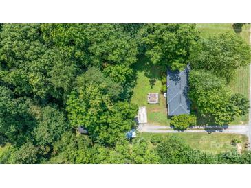 An aerial view of a home surrounded by lush trees in a serene, wooded neighborhood at 5914 Mt Holly Huntersville Rd, Charlotte, NC 28216