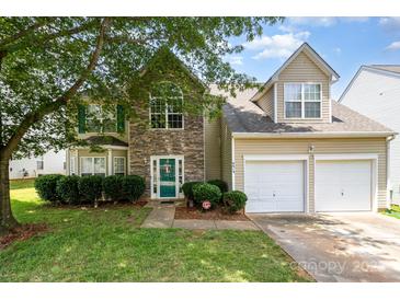 Charming two-story home featuring a stone facade, well-manicured lawn, and attached two-car garage at 6619 Bittinger Ct, Charlotte, NC 28216