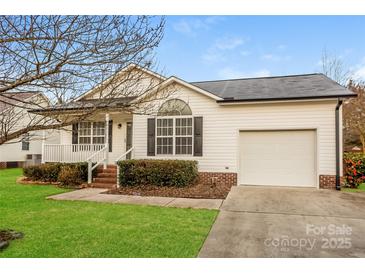 Charming single-story home with white siding, a well-manicured lawn, and an attached single-car garage at 828 Saint Andrews Pl, Concord, NC 28025