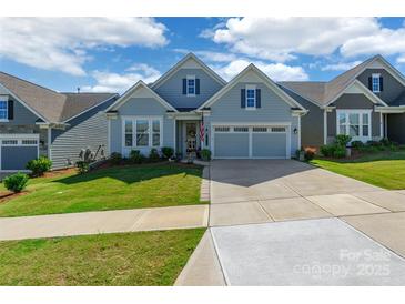 Charming single-Gathering home featuring a well-maintained lawn and two-car garage on a sunny day at 8516 Profit Ln, Charlotte, NC 28215