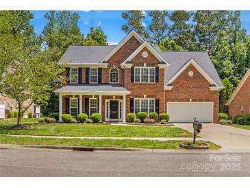 Charming two-story brick home with well-manicured lawn, black shutters, and inviting front entrance at 1011 Wadsworth Ln, Indian Trail, NC 28079