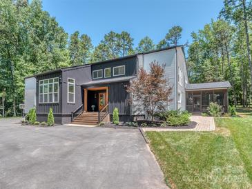 Striking modern home with black and gray siding, manicured landscaping, and a welcoming front entrance at 202 Walden Ln, Weddington, NC 28104