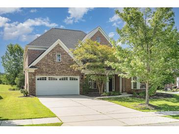 Beautiful two-story home featuring a stone and brick facade, three-car garage, and well-manicured lawn at 2100 Goddard Way, Waxhaw, NC 28173