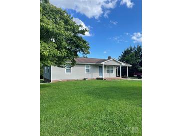 Charming single-story home with a well-manicured lawn and covered front porch at 28518 Flint Ridge Rd, Albemarle, NC 28001