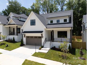Charming two-story home with a white exterior, gray garage door, and well-manicured lawn at 3949 Plainview Rd, Charlotte, NC 28208