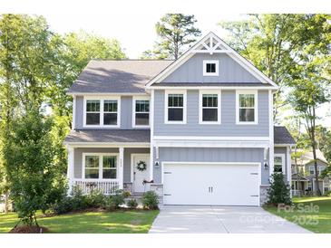 Charming two-story home with a covered porch, attached garage, and well-maintained landscaping at 5499 Angus Dr, Midland, NC 28107