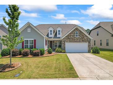 Charming single-Gathering home featuring a manicured lawn, stone accents, and an attached two-car garage at 9547 Horsebit Ln, Concord, NC 28027