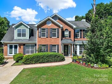 Charming two-story brick home features manicured landscaping and a welcoming front entrance at 9800 Ashley Farm Dr, Matthews, NC 28105