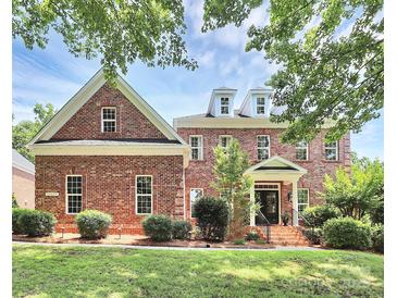 Stunning two-story brick home featuring manicured landscaping and a charming front entrance at 13824 Glen Abbey Dr, Charlotte, NC 28278