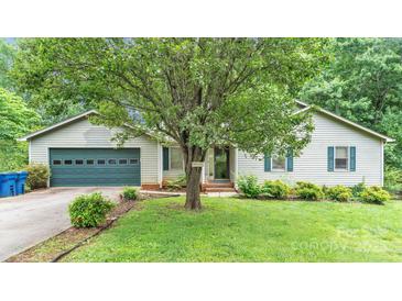 Charming single-story home featuring a blue garage door, lush lawn, and mature landscaping, creating a welcoming curb appeal at 1713 Poe Cir, Hickory, NC 28601