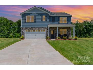 Charming two-story home featuring stone accents, attached two-car garage, and manicured lawn at 3654 Azalea Ridge Dr, Mount Holly, NC 28102