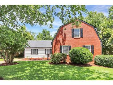 Charming two-story red brick home with a detached garage and lush landscaping at 3909 Woodbriar Trl, Charlotte, NC 28205