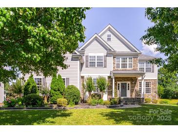 Charming two-story home featuring a well-manicured lawn and beautifully landscaped front yard at 7737 Pleasant Valley Dr, Harrisburg, NC 28075