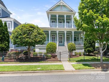 Charming light blue two-story home with double porches, white pillars, and a well-manicured front yard at 8918 Cotton Press Rd, Charlotte, NC 28277