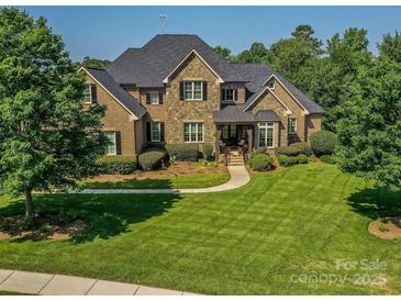 Stunning stone and brick home with lush landscaping and manicured lawn at 1377 Shinnecock Ln, Fort Mill, SC 29707