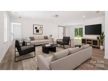 Inviting living room with ample seating, modern decor, and large sliding doors offering scenic views at 157 Fraley Rd, Gastonia, NC 28052