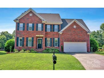 Traditional two-story brick home featuring a well-manicured lawn and a two-car garage at 2117 Copperplate Rd, Charlotte, NC 28262