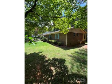 Brick ranch-style home with manicured lawn, featuring light blue shutters and mature tree shade at 2300 Lakeview Cir # 10, Matthews, NC 28105