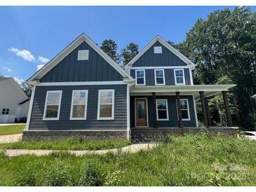 Charming two-story home featuring a covered porch, gray siding, and a well-manicured lawn at 3218 Player Ct, Salisbury, NC 28144