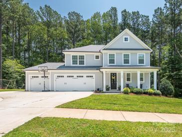 Inviting two-story home with a three-car garage, a basketball hoop, and a charming front porch at 3227 Cape Fox Ct, Denver, NC 28037