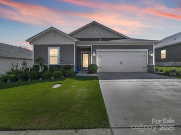 Charming single-Gathering home with a well-manicured lawn and two-car garage at dusk at 3317 Black Cherry Dr, Monroe, NC 28110