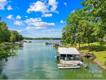 Beautiful lake view featuring a private dock and boat slip on a sunny day at 698 Normandy Rd, Mooresville, NC 28117