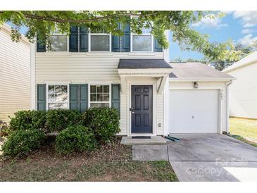 Charming two-story home featuring a single-car garage and a well-maintained front yard with lush greenery and dark blue shutters at 7643 Monarch Birch Ln, Charlotte, NC 28215